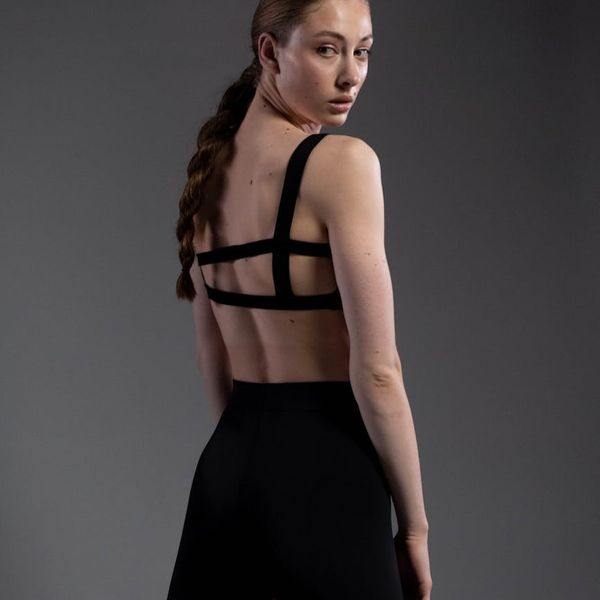 Person standing strong in a yoga warrior pose against a minimal background.